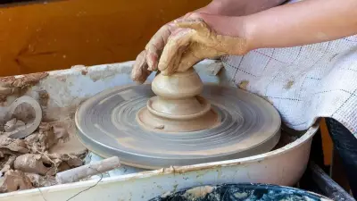مرسم فني خالٍ تتناثر فيه أدوات الرسم ولوحة بألوان ترابية