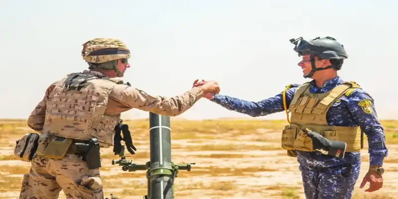 مدرب عسكري من «التحالف الدولي» يصافح جندياً عراقياً في أحد معسكرات التدريب
