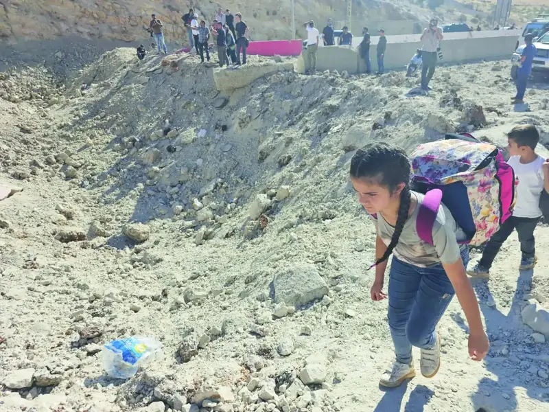 أشخاص يحملون أمتعتهم أثناء عبورهم من لبنان إلى سوريا